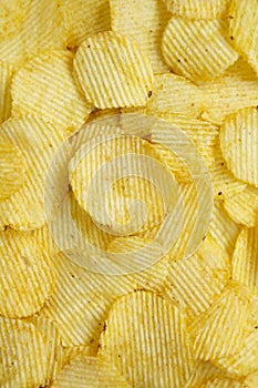 Salted wavy potato chips, top view. Overhead, from above, flat lay. Close-up