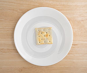 Saltine cracker on a plate atop wood table photo
