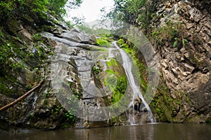 Salto del Mico waterfall surrounded by rocks in Villeta, Colombi photo