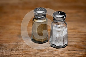 Saltshaker and pepper shaker on a wooden table. photo