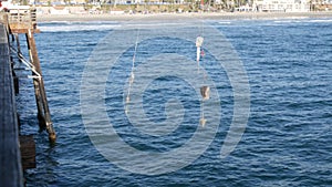 Saltwater angling on pier, fishing tackle or gear. California USA. Sea ocean water, rod or spinning.