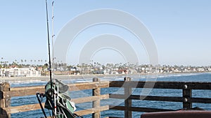 Saltwater angling on pier, fishing tackle or gear. California USA. Sea ocean water, rod or spinning.