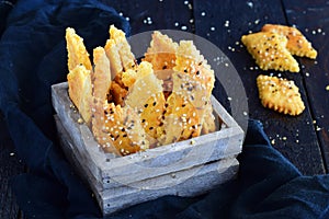 Salty biscuits with sesame seeds in a wooden box