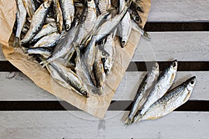 Salty dried fish on the brown paper. Small stock-fish.