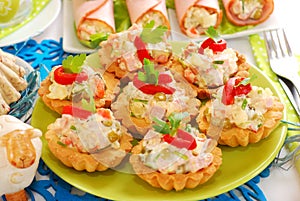 Salty mini tartlets stuffed with vegetable and ham salad