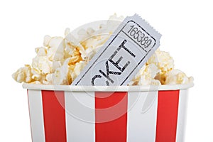 Salty popcorn in box and movie ticket, isolated on white.