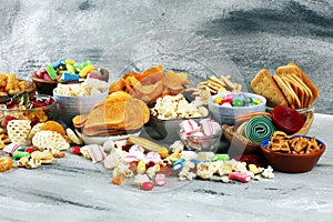 Salty snacks. Pretzels, chips, crackers and candy sweets on table