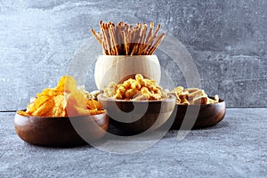 Salty snacks. Pretzels, chips, crackers in wooden bowls