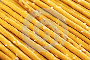 Salty sticks line in row background. Top view. Snack texture background. Salty bread sticks for beer background pattern