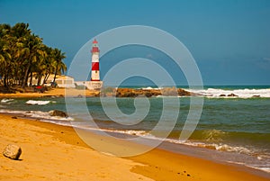 SALVADOR, BAHIA, BRAZIL: Farol De Itapua on the rough sea. Lighthouse on the beach in Sunny weather