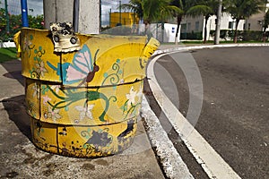 Yellow and recyclable waste basket decorated with nature motifs Borboleta on a public photo