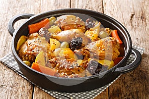 Salvadoran chicken stew with chicha, prunes, carrots, potatoes, olives and onions close-up in a frying pan. Horizontal