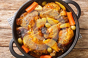 Salvadoran chicken stew with chicha, prunes, carrots, potatoes, olives and onions close-up in a frying pan. Horizontal top view