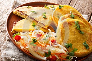 Salvadoran food fried Pupusas served with coleslaw close-up on a plate. horizontal