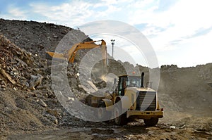 Salvaging and recycling building and construction materials. Industrial waste treatment plant. Excavator and a front-end loader