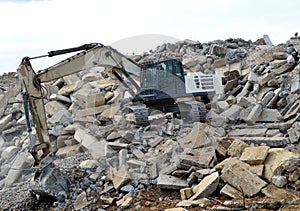 Salvaging and recycling building and construction materials. Industrial waste treatment plant. Excavator work at landfill with