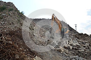 Salvaging and recycling building and construction materials. Industrial waste treatment plant. Excavator work at landfill with