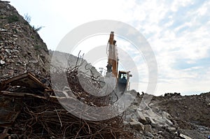 Salvaging and recycling building and construction materials. Industrial waste treatment plant. Excavator work at landfill with