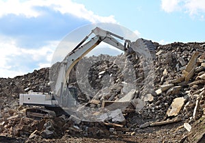 Salvaging and recycling building and construction materials. Industrial waste treatment plant. Excavator work at landfill with