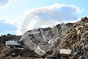 Salvaging and recycling building and construction materials. Industrial waste treatment plant. Excavator work at landfill with