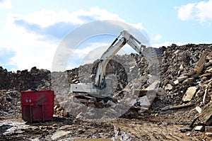 Salvaging and recycling building and construction materials. Industrial waste treatment plant. Excavator work at landfill with con