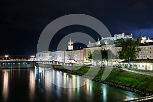 Salzburg, Austria, August 15, 2022. Fascinating night shot of the historic center overlooking the river. Behind, on the hill, the