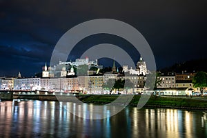 Salzburg, Austria, August 15, 2022. Fascinating night shot of the historic center overlooking the river. Behind, on the hill, the