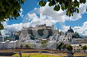 Salzburg, Austria, August 15, 2022. Stunning postcard of the historic center with the branches of a tree framing the fort on the