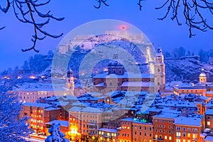 Salzburg, Austria: Heavy snow on the historic city of Salzburg with famous Festung Hohensalzburg and Salzach river in winter photo