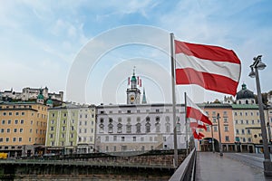 Salzburg Skyline view with Austrian flags, the Old Town Hall Clock Tower and Hohensalzburg Fortress - Salzburg, Austria