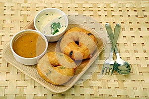 Sambar vada with sambar and coconut chutney a South Indian food, on wooden background