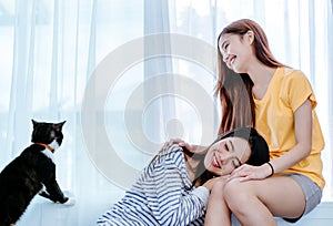 Same sex asian lesbian couple lover playing cute cat pet