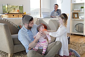 Same sex couple at home with daughters