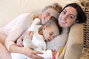 Same sex couple snuggling with their baby son