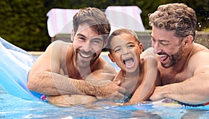 Same Sex Family With Two Dads And Son On Holiday In Swimming Pool Together