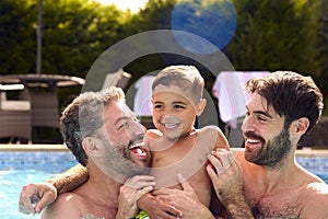 Same Sex Family With Two Dads And Son On Holiday In Swimming Pool Together