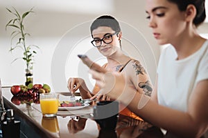 Same Sex Lgbt Partners Eating Food And Typing On Telephone