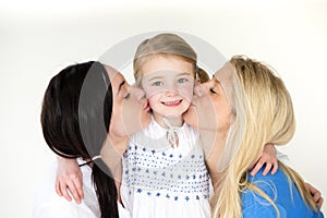 Same sex mothers kissing their daughter