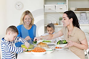 Same sex parents having dinner with children