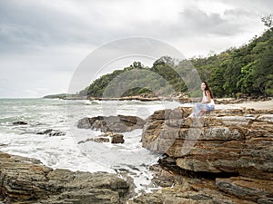 Samed, Thailand. Asian woman traveler on a cliff rock with beautiful seascape.