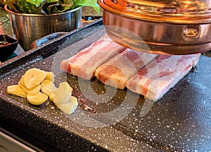 Samgyeopsal - Traditional Korean pork belly barbecue grilled with vegetable and garlic