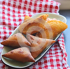 Samoosas and half Moons on a tray