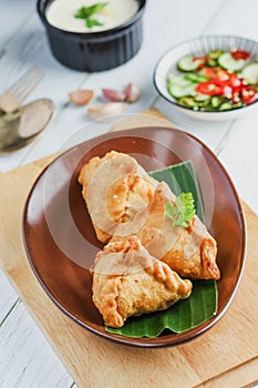 Samosa on a plate with sauce. Indian fried pastry