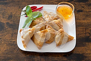 Samosa in a white plate with sweet and sour sauce