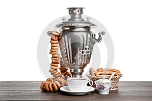 Samovar with hot tea, jam and delicious ring shaped Sushki (dry bagels) on table against white background