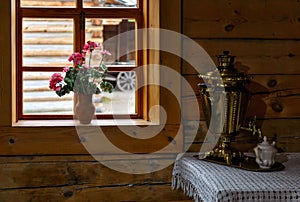 Samovar at old style Russian kitchen in wooden house with window