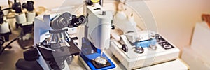 A sample preparation table in a laboratory with an optical microscope, ultrasonic cutter system and precision micrometer grinder p