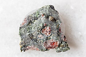 sample of pyrope garnets in raw rock on white