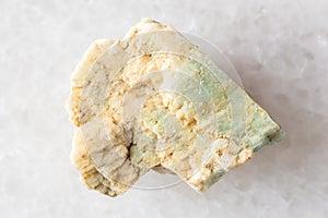 sample of raw amazonite rock on white marble