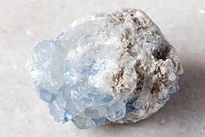 sample of raw celestite rock on white marble